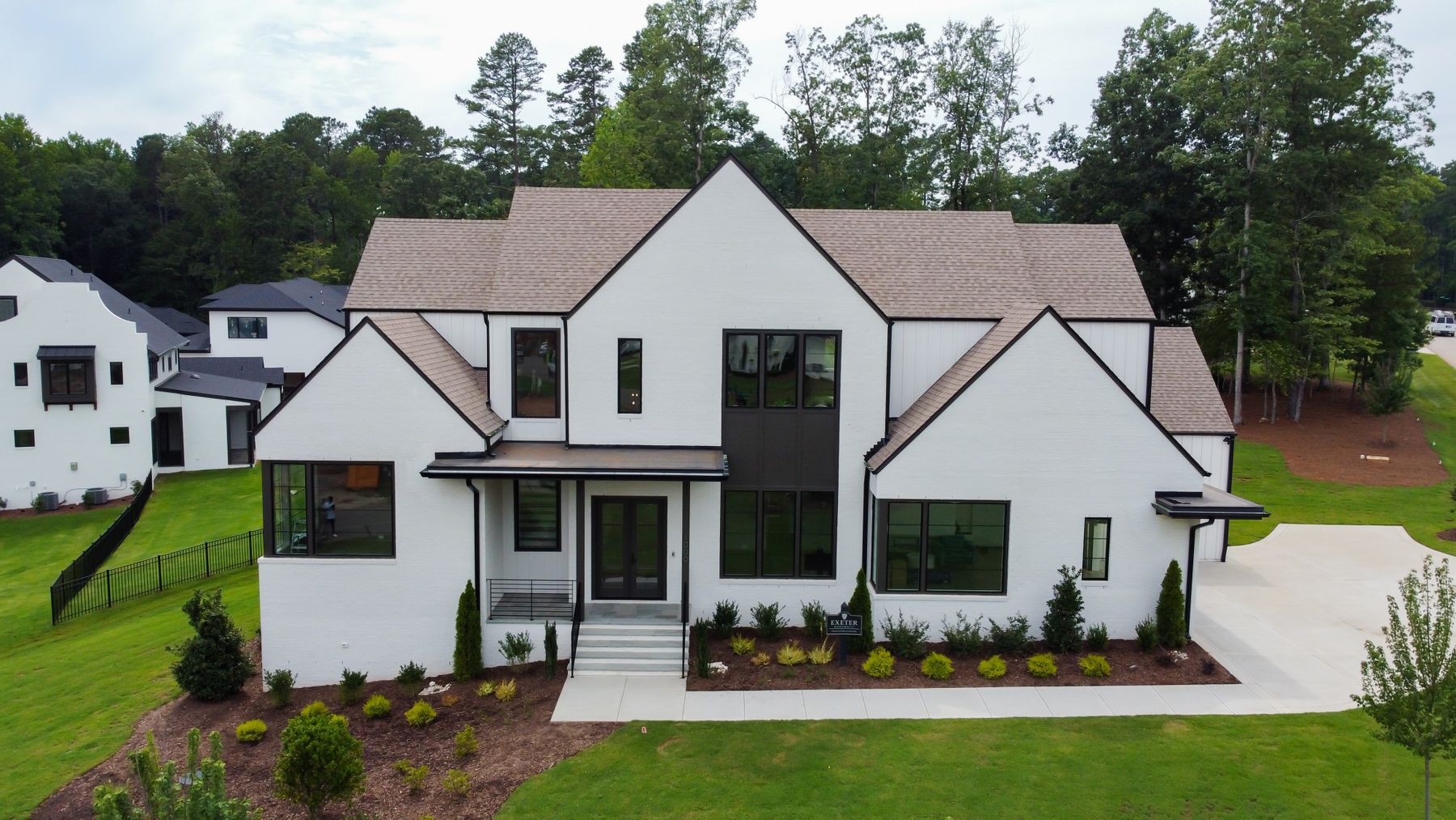Illustrative aerial photograph of a modern white home framed by a green landscape