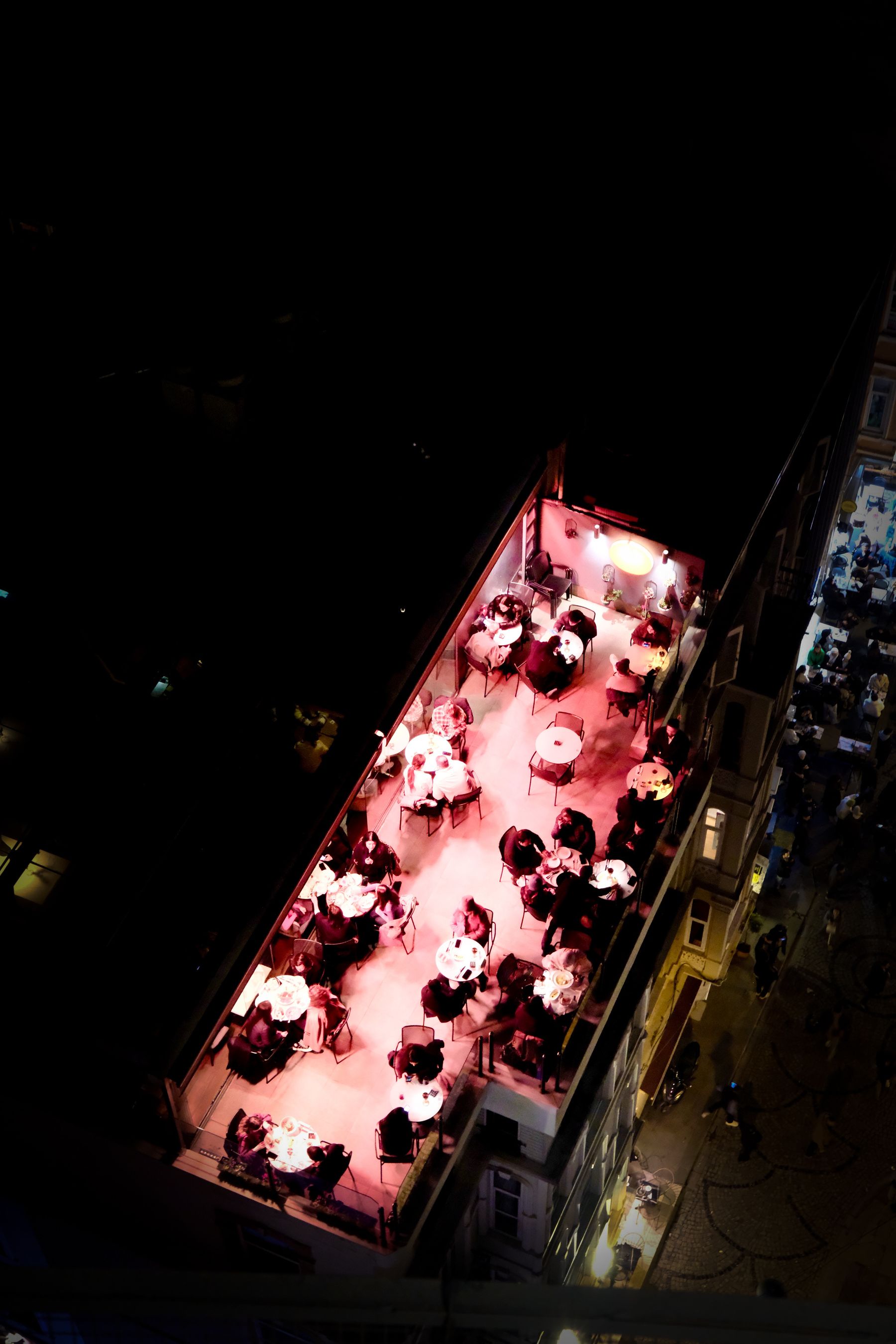 Illustrative aerial photograph of a rooftop restaurant glowing at night